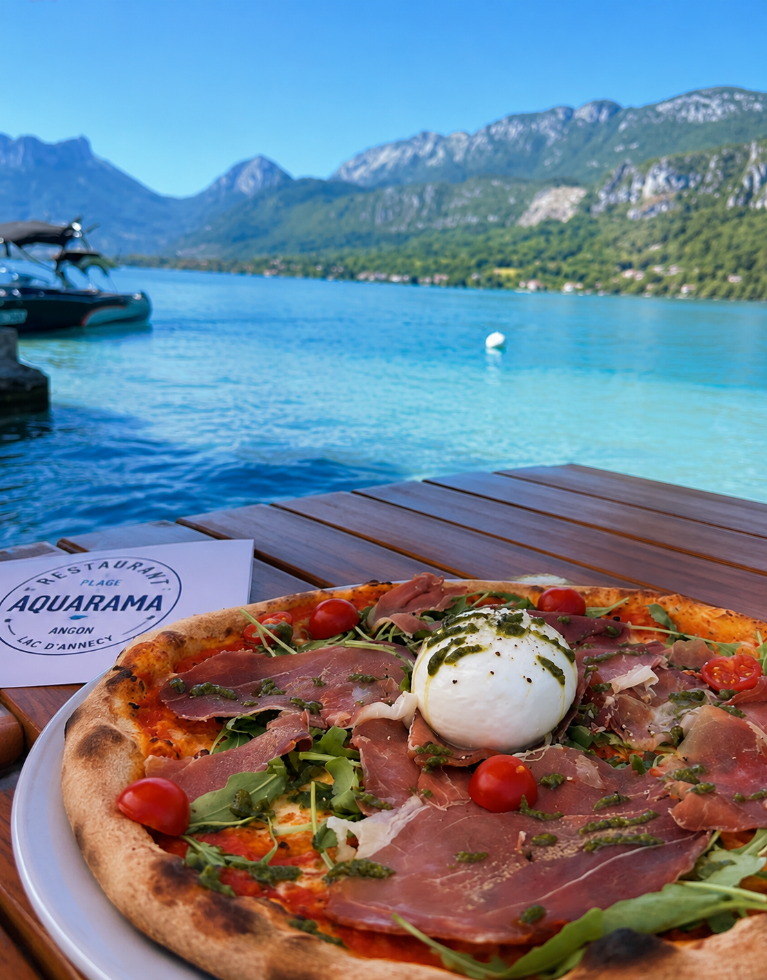 Pizza burrata et jambon cru servie sur le ponton face au lac d'Annecy